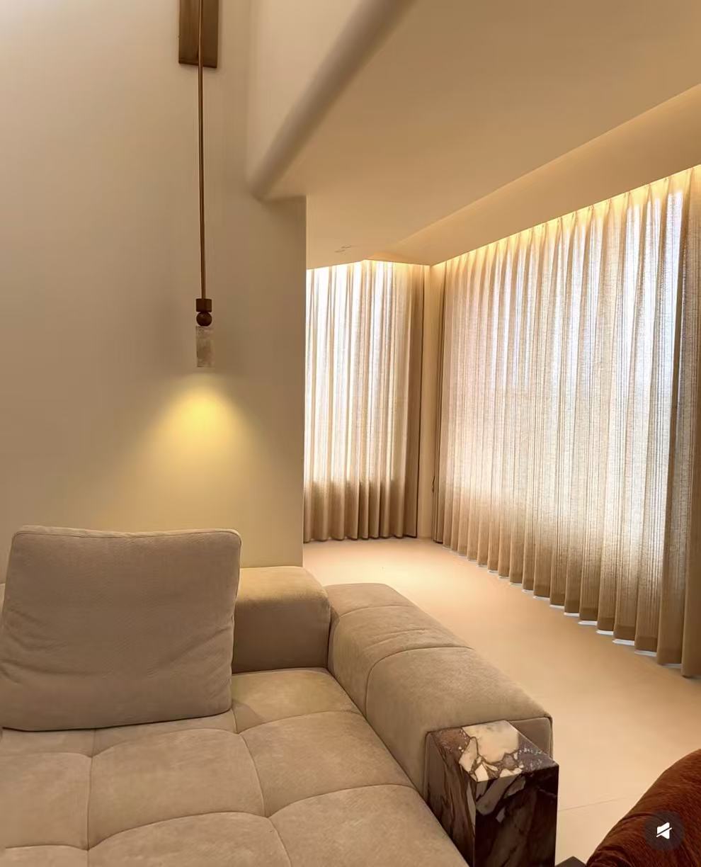 Cove-lit S-fold sheers wrapping a lounge