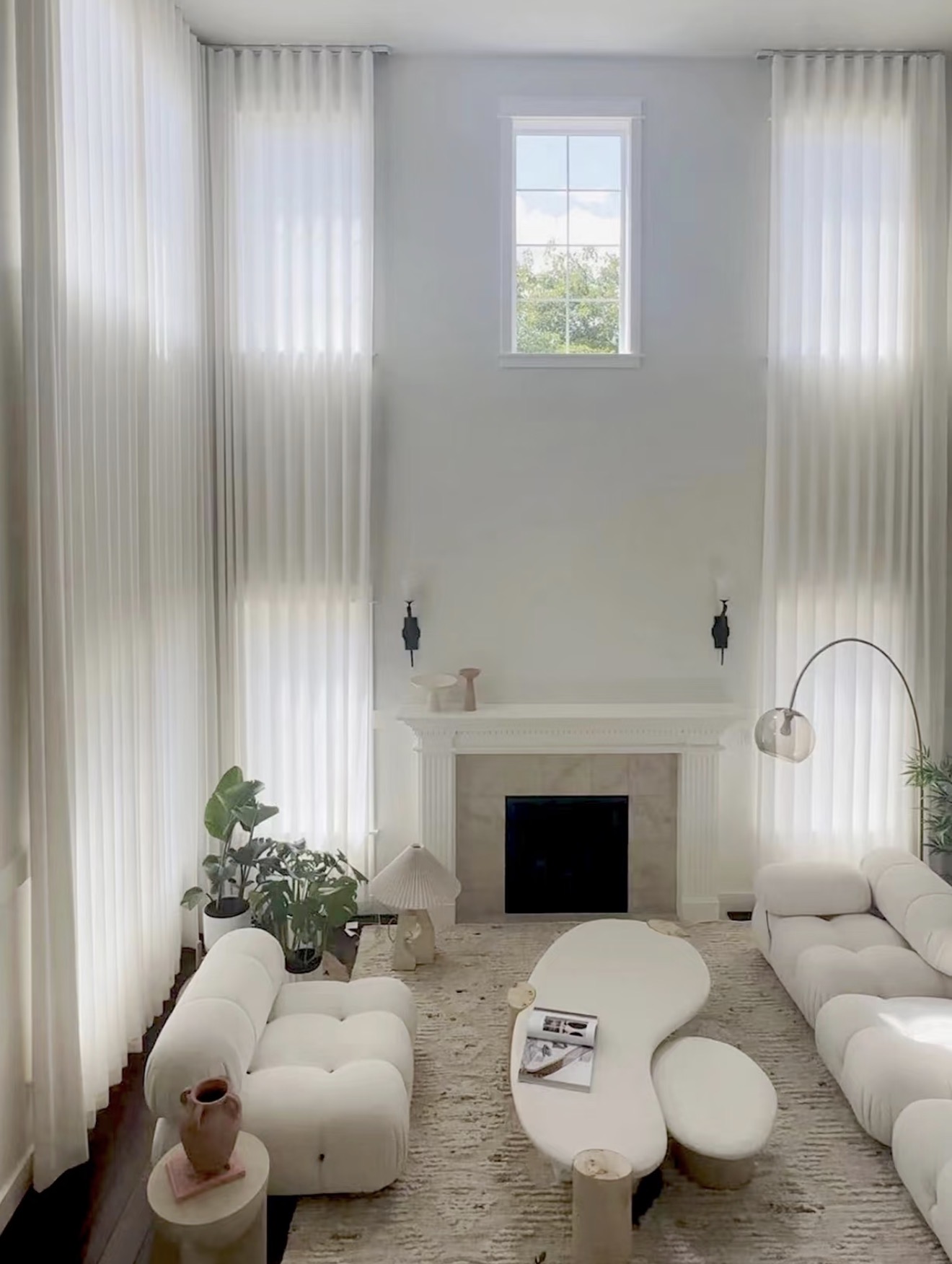 Double-height living room with soft sheer and blockout curtains
