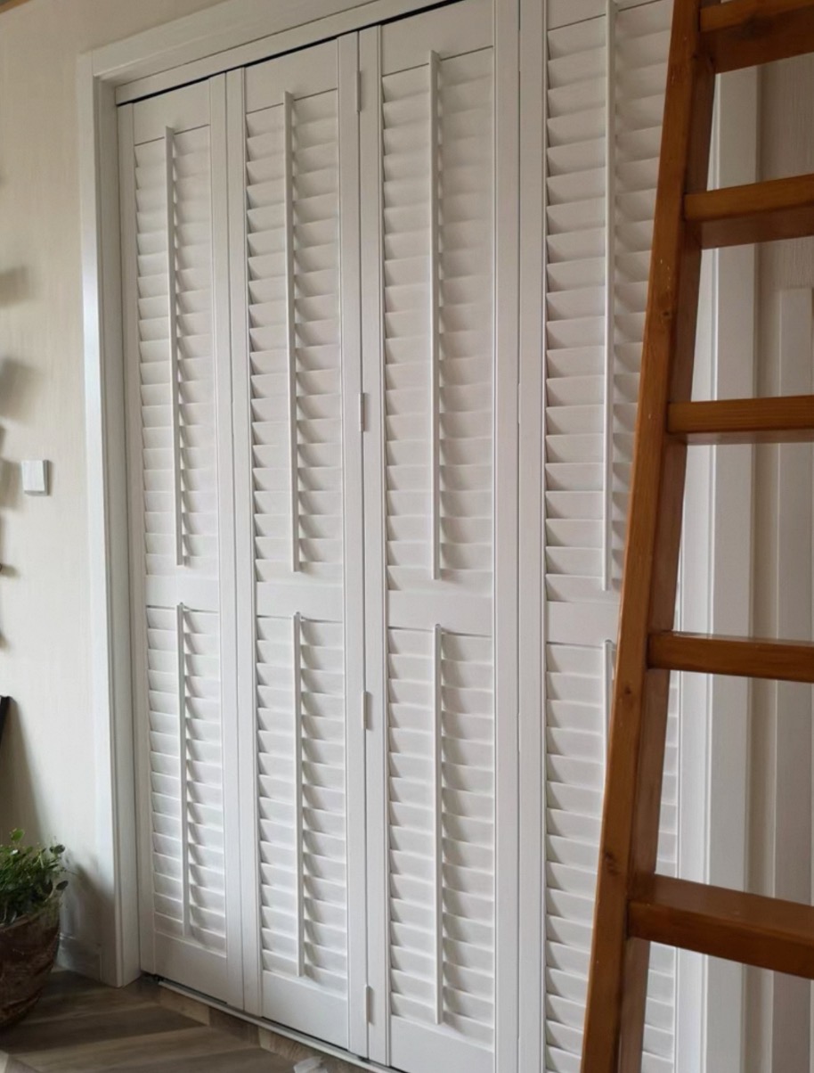 Tracked bi-fold shutters across a doorway