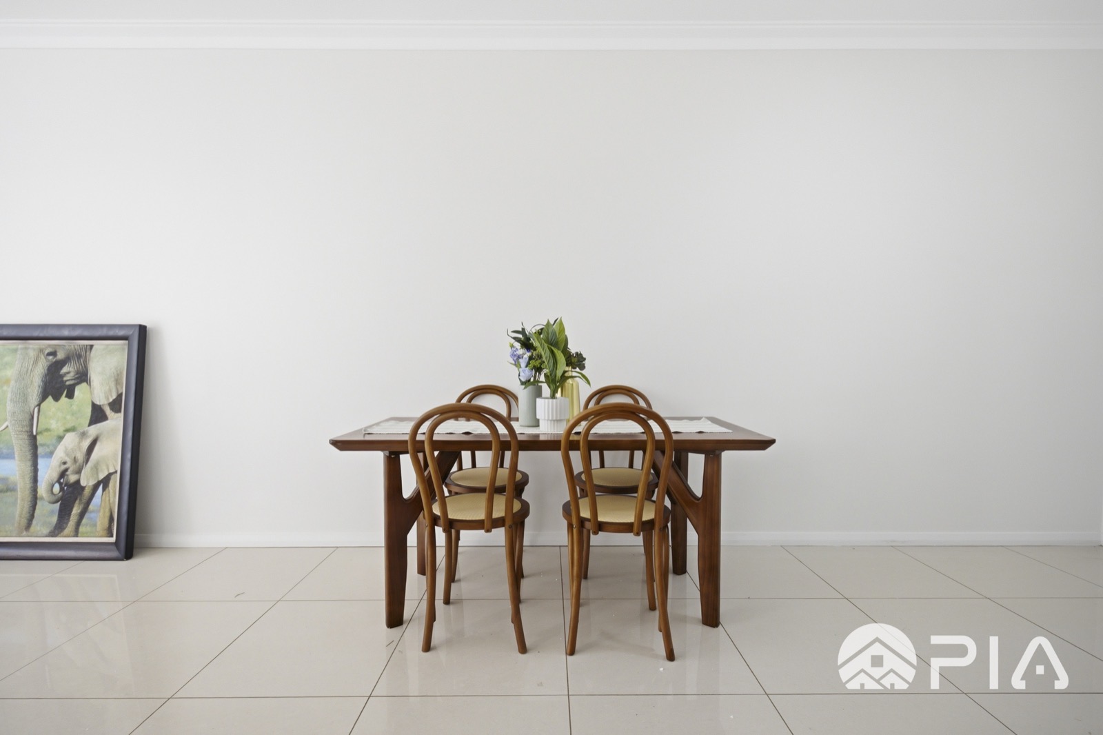 Airbnb dining setting with timber table and feature artwork