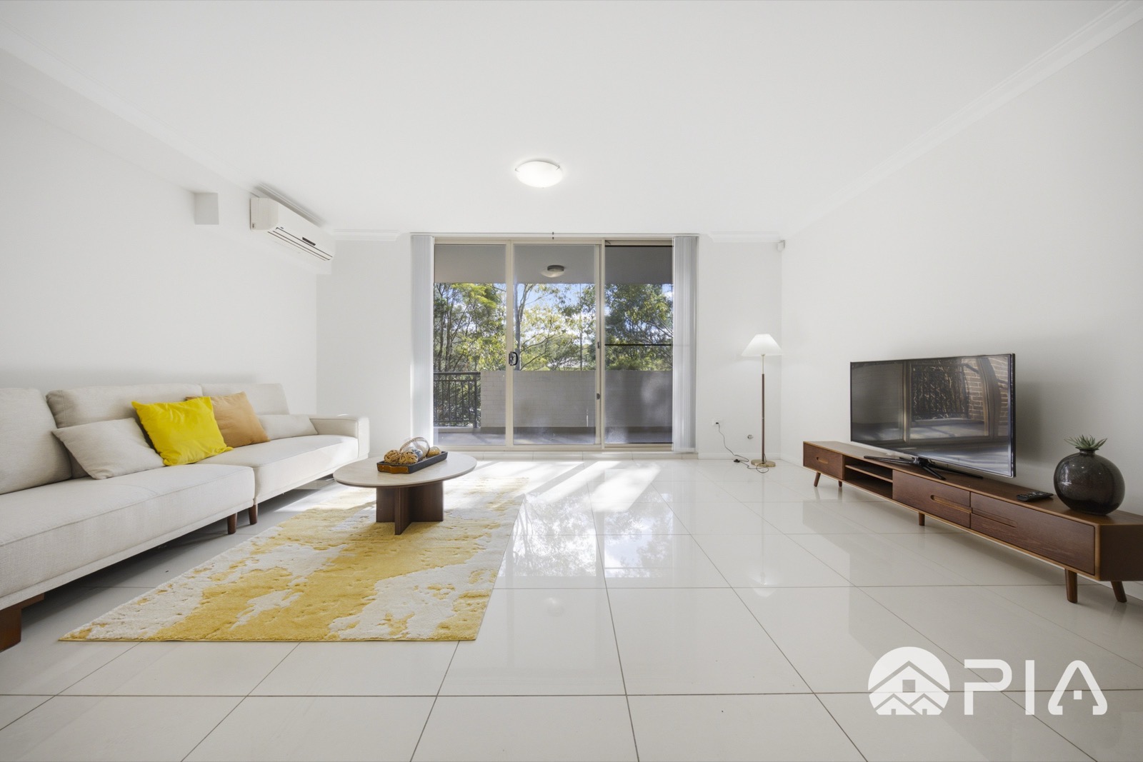 Airbnb living room styled with bouclé sofa and yellow rug