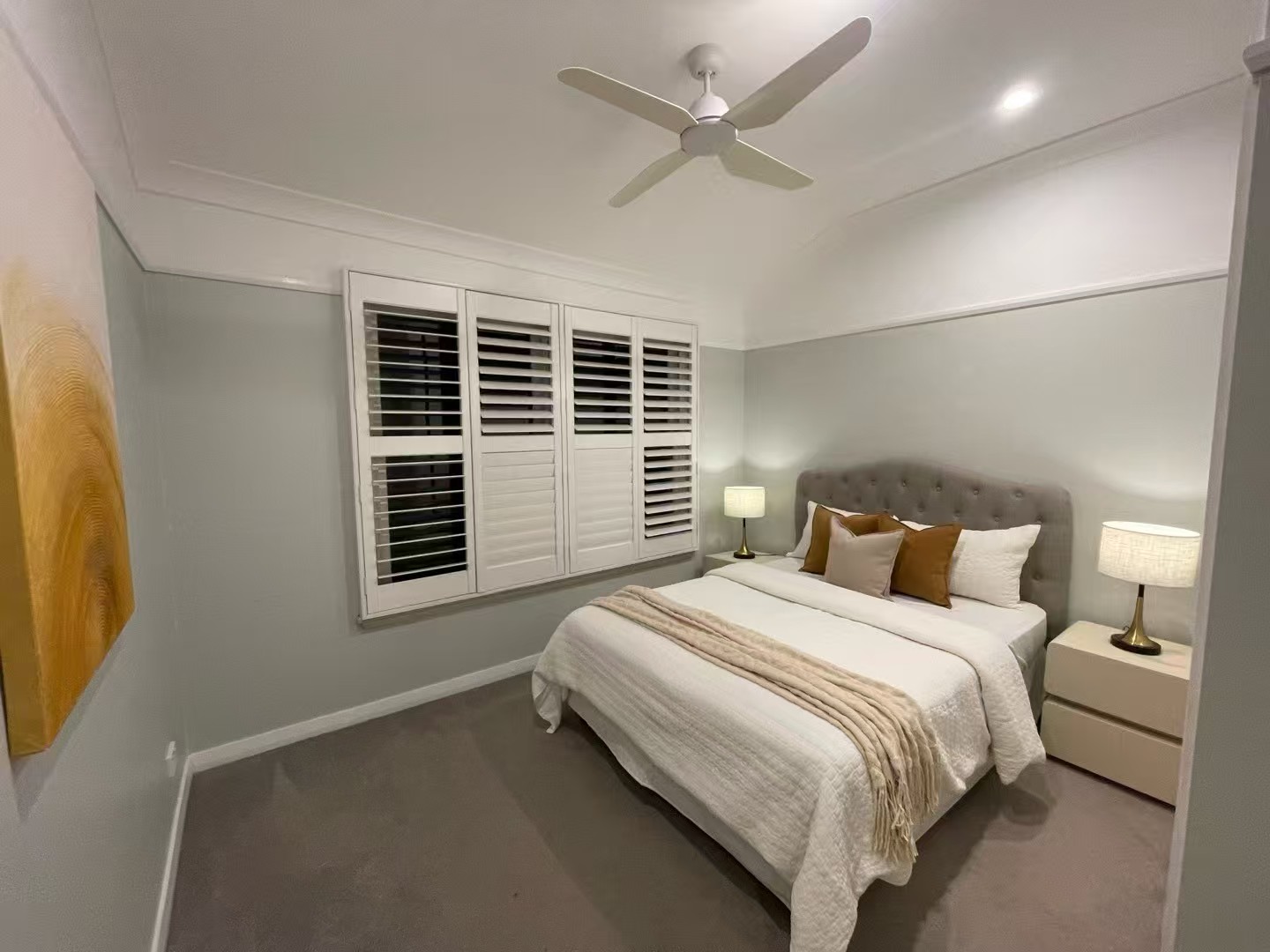 Bedroom styled for evening with plantation shutters