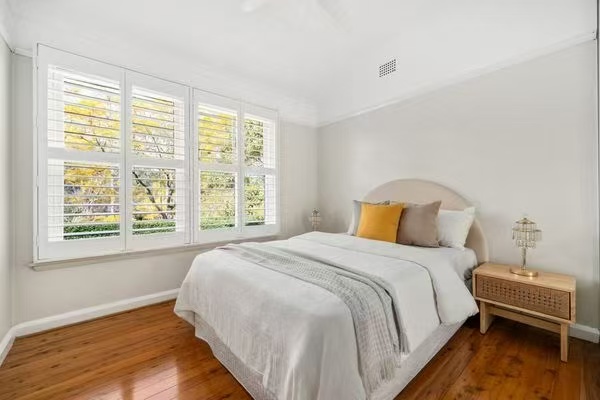 Bedroom with plantation shutters and timber floor
